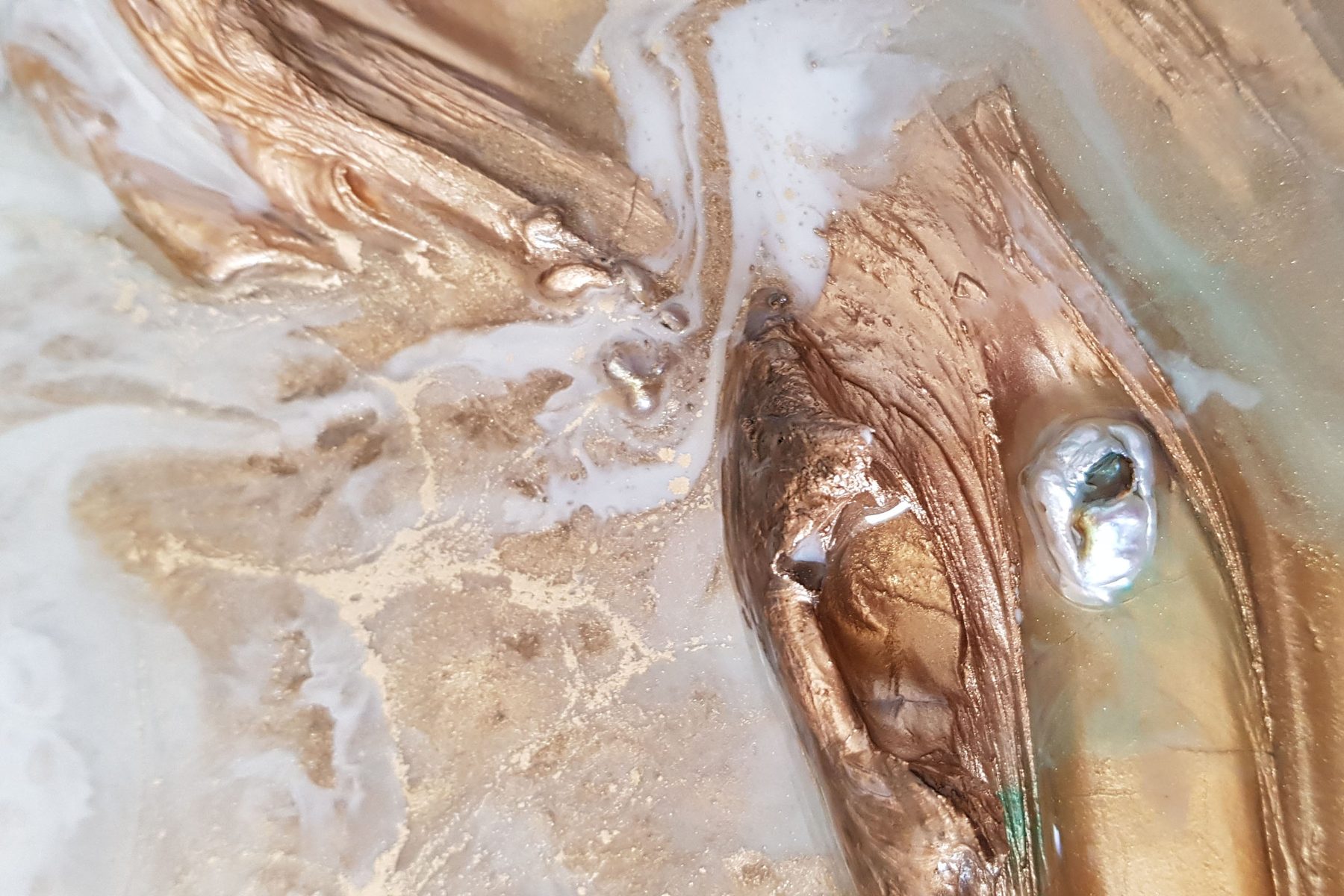 Macro detail of a resin pour in ocean blue, white and gold